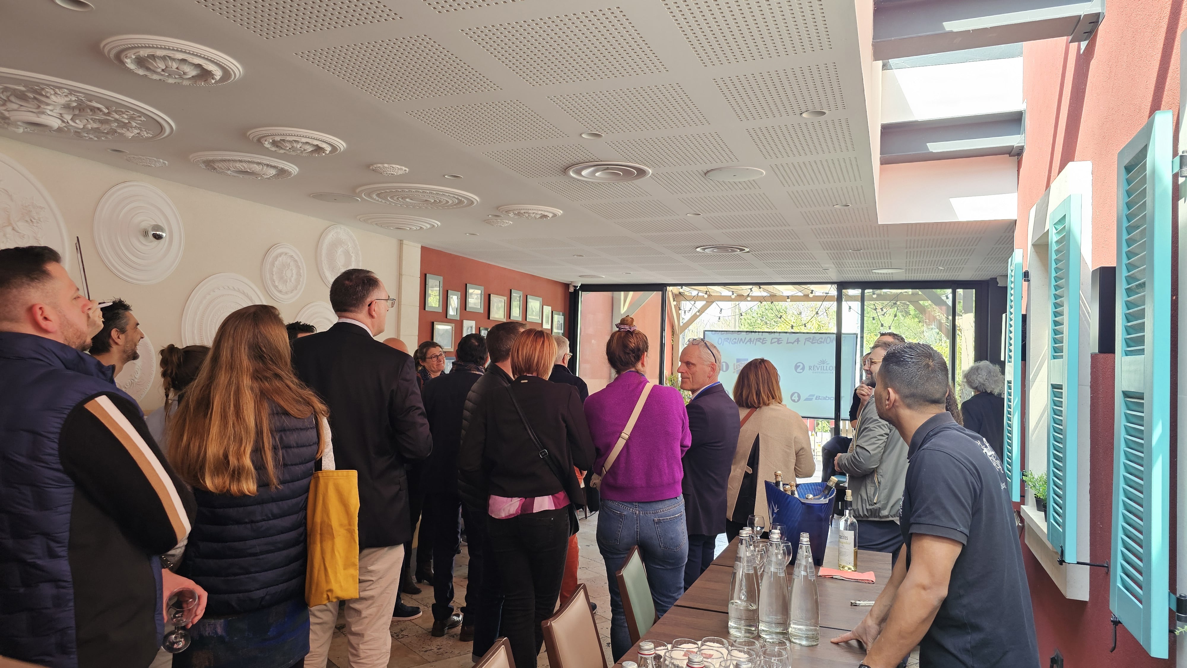 Convives réunis pour un événement chez Fabioli, entre la salle aux médaillons et la terrasse ombragée aux volets turquoise
