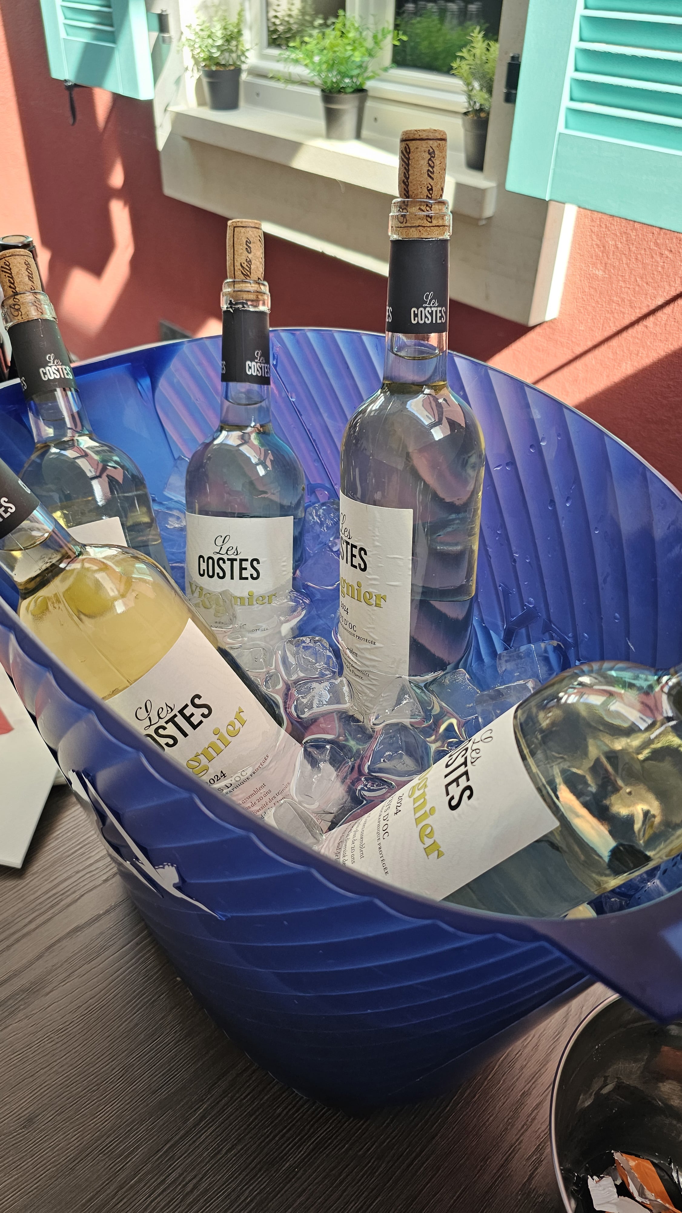 Bouteilles de vin blanc Les Costes Viognier au frais dans un seau à glace sur la terrasse Fabioli