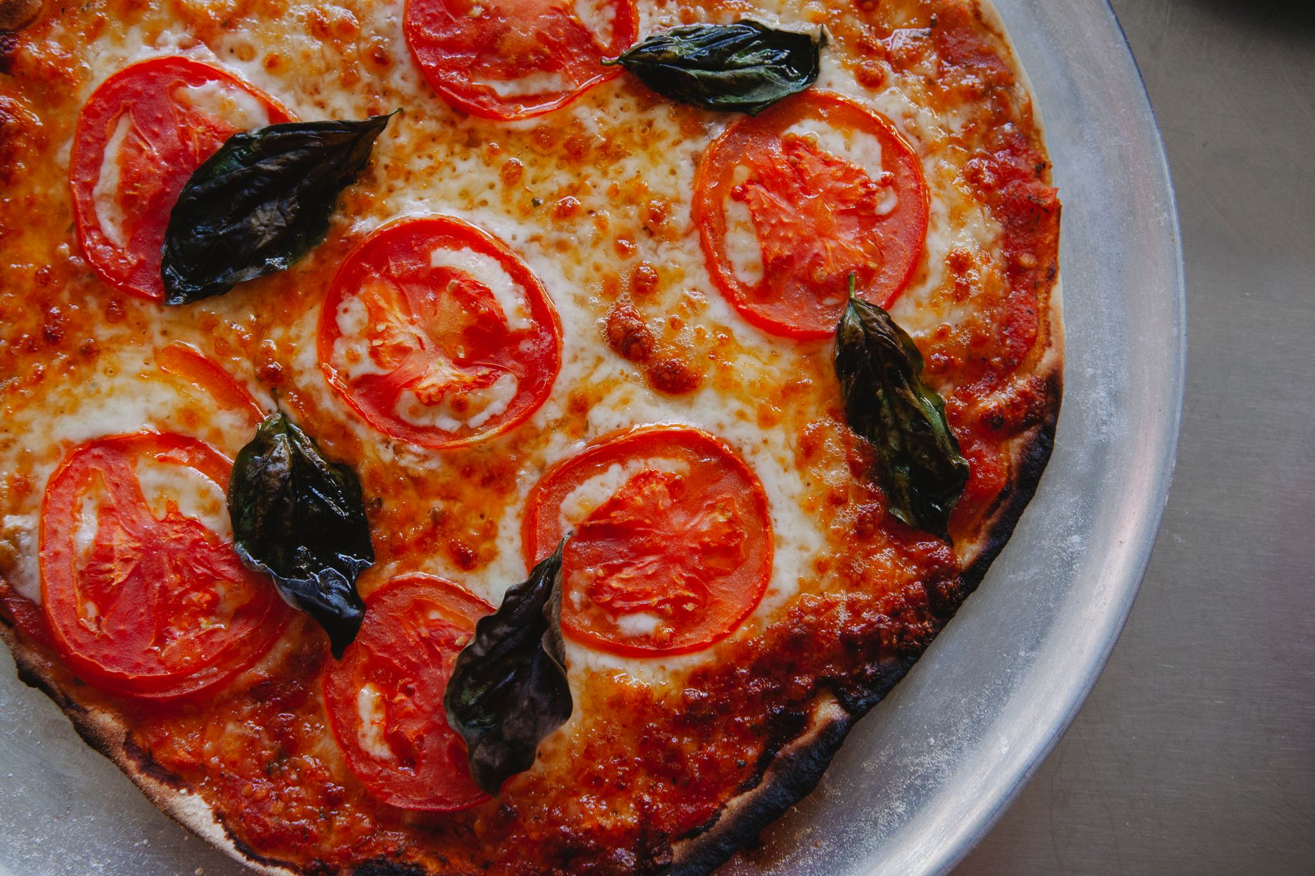 Pizza romaine Margherita à la pâte fine et croustillante, mozzarella, tomate et basilic frais