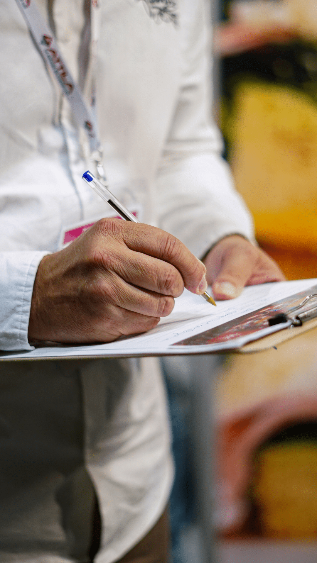 Visiteur prenant des notes sur un formulaire lors d'un salon de la franchise