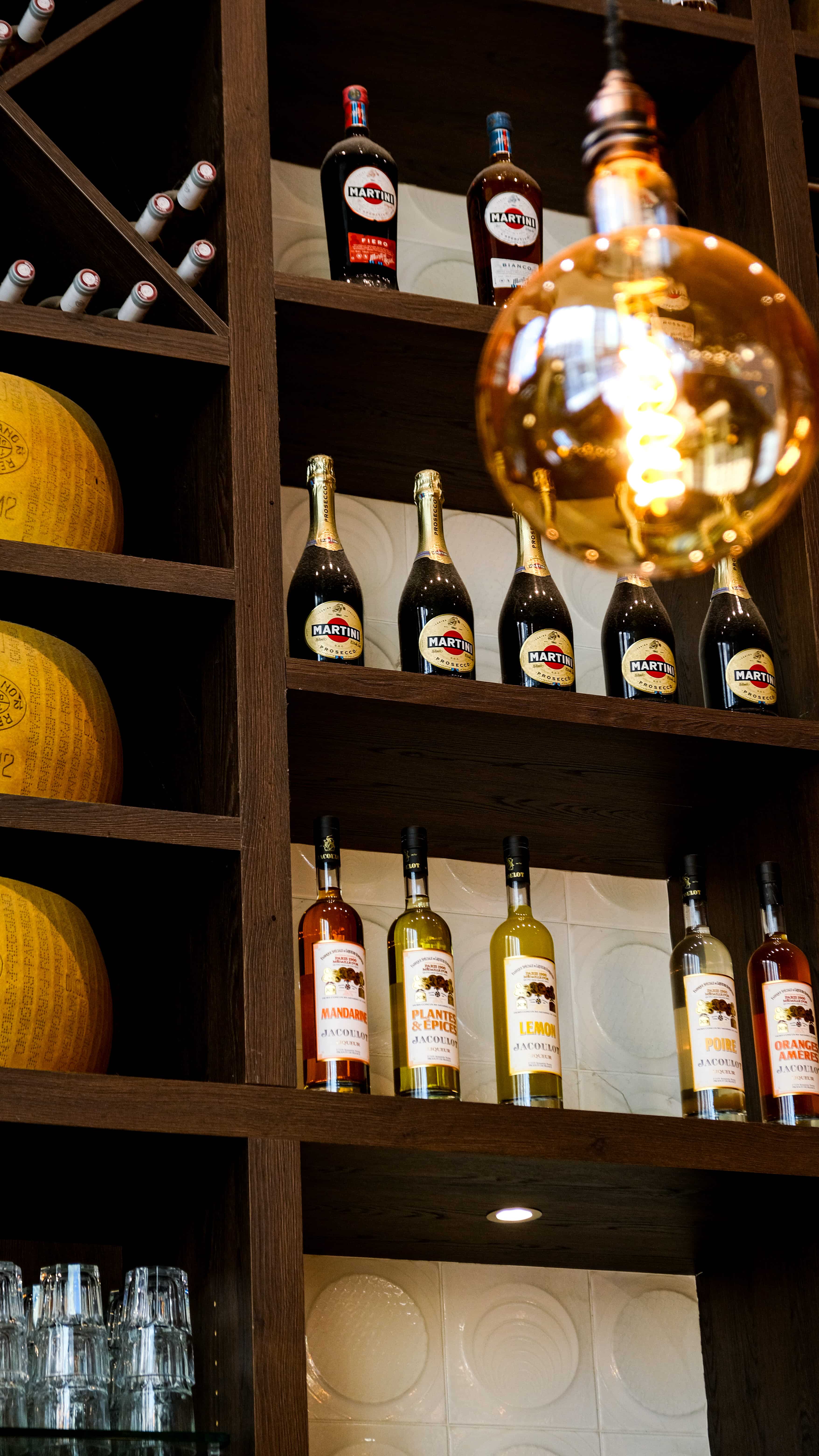 Étagère du bar Fabioli garnie de meules de parmesan, Martini, prosecco et liqueurs